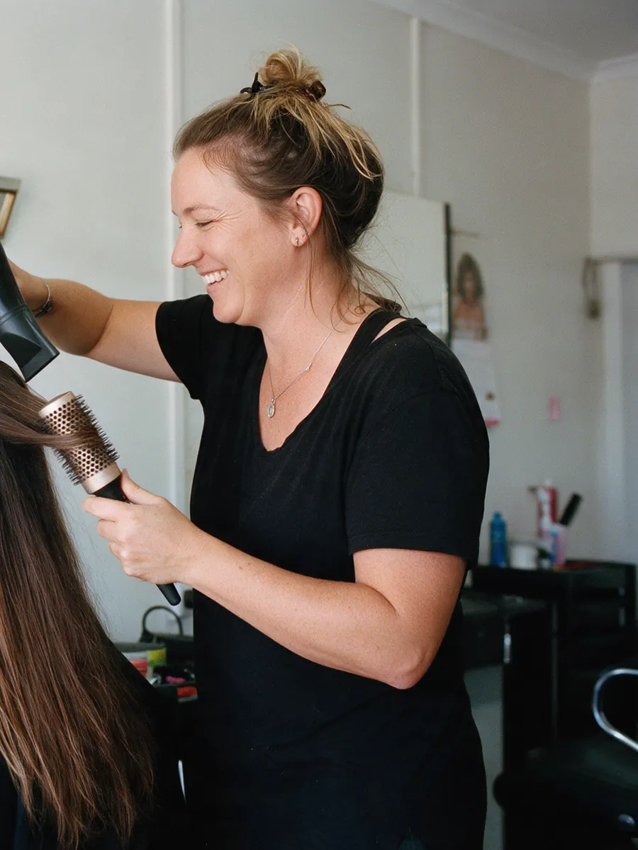 Mia Torres blow-drying a client’s hair